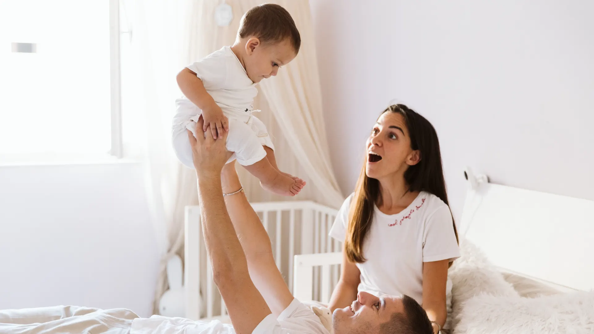 Bambino di un anno che gioca sul tappeto insieme alla mamma